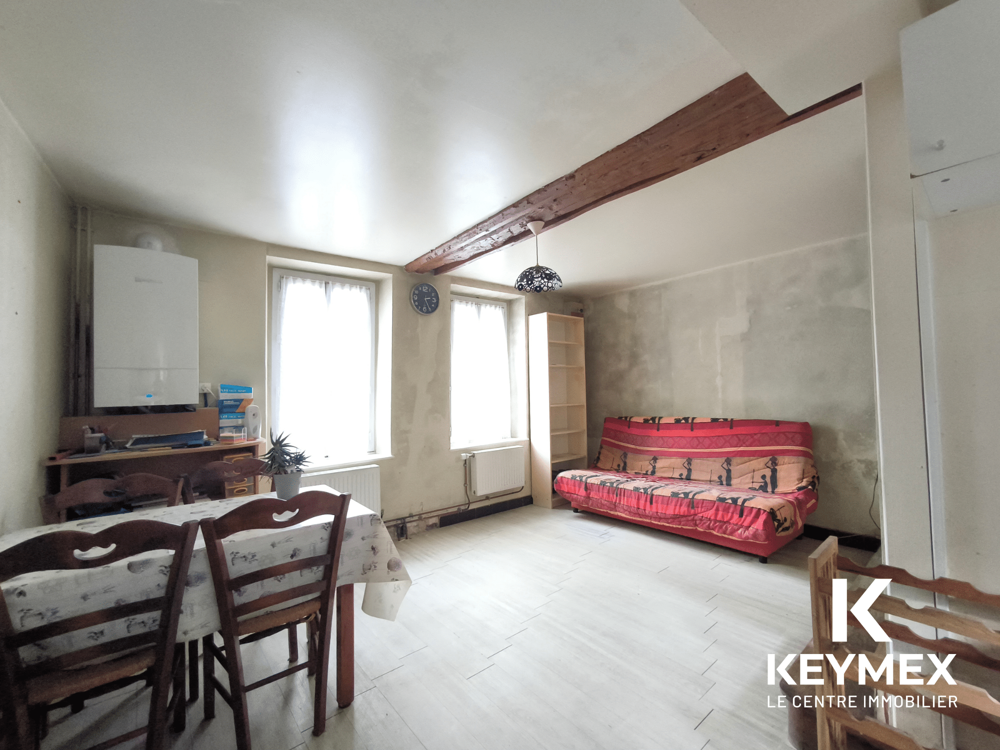 Salon lumineux avec canapé et table à manger.