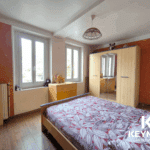 Chambre lumineuse avec armoire et lit double.