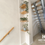 Escalier moderne avec plantes vertes et étagères.