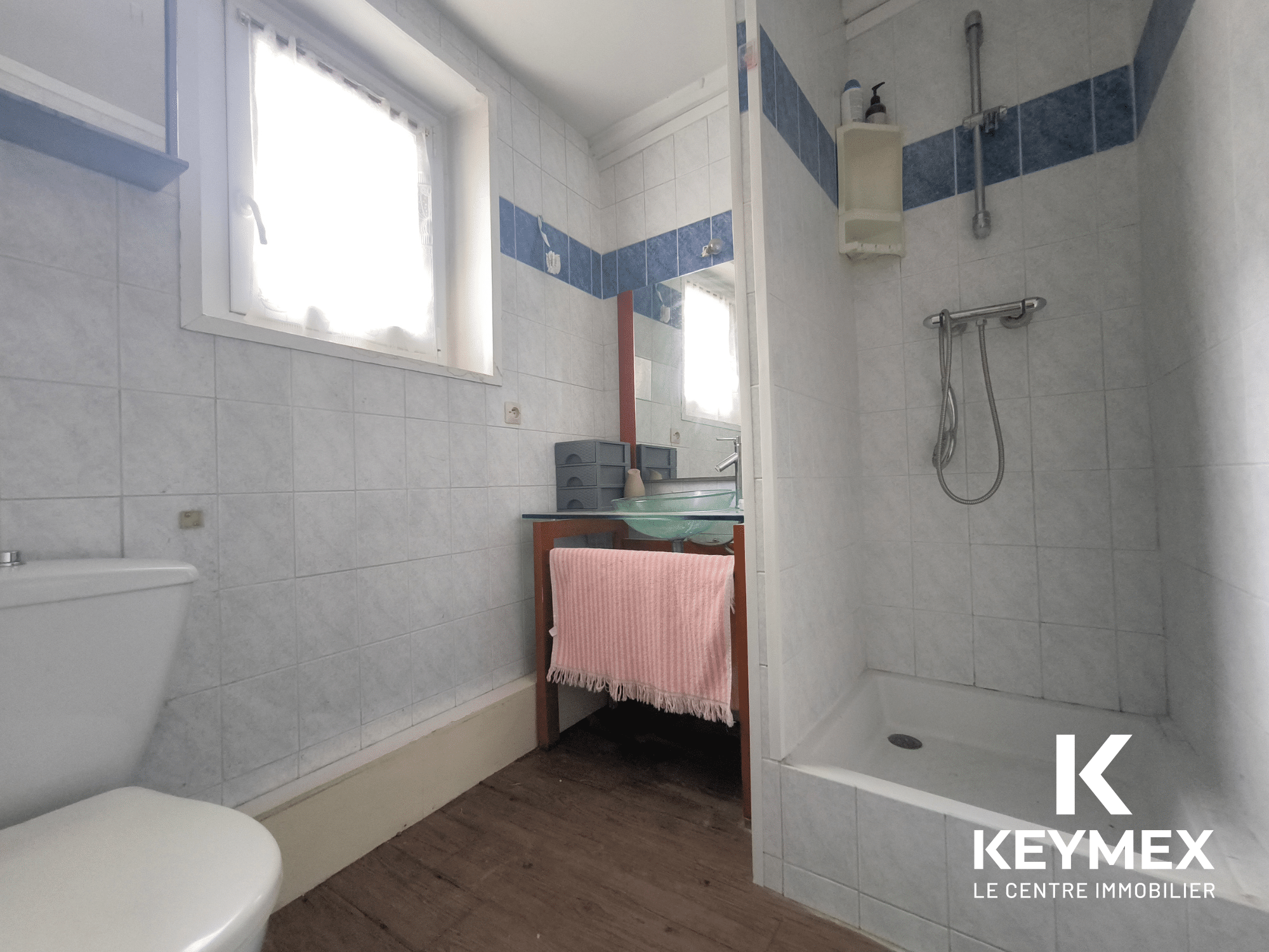 Salle de bain moderne avec douche et lavabo.