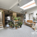 Salon lumineux avec plantes et escaliers modernes.
