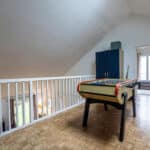 Salle de jeux avec baby-foot sur mezzanine.