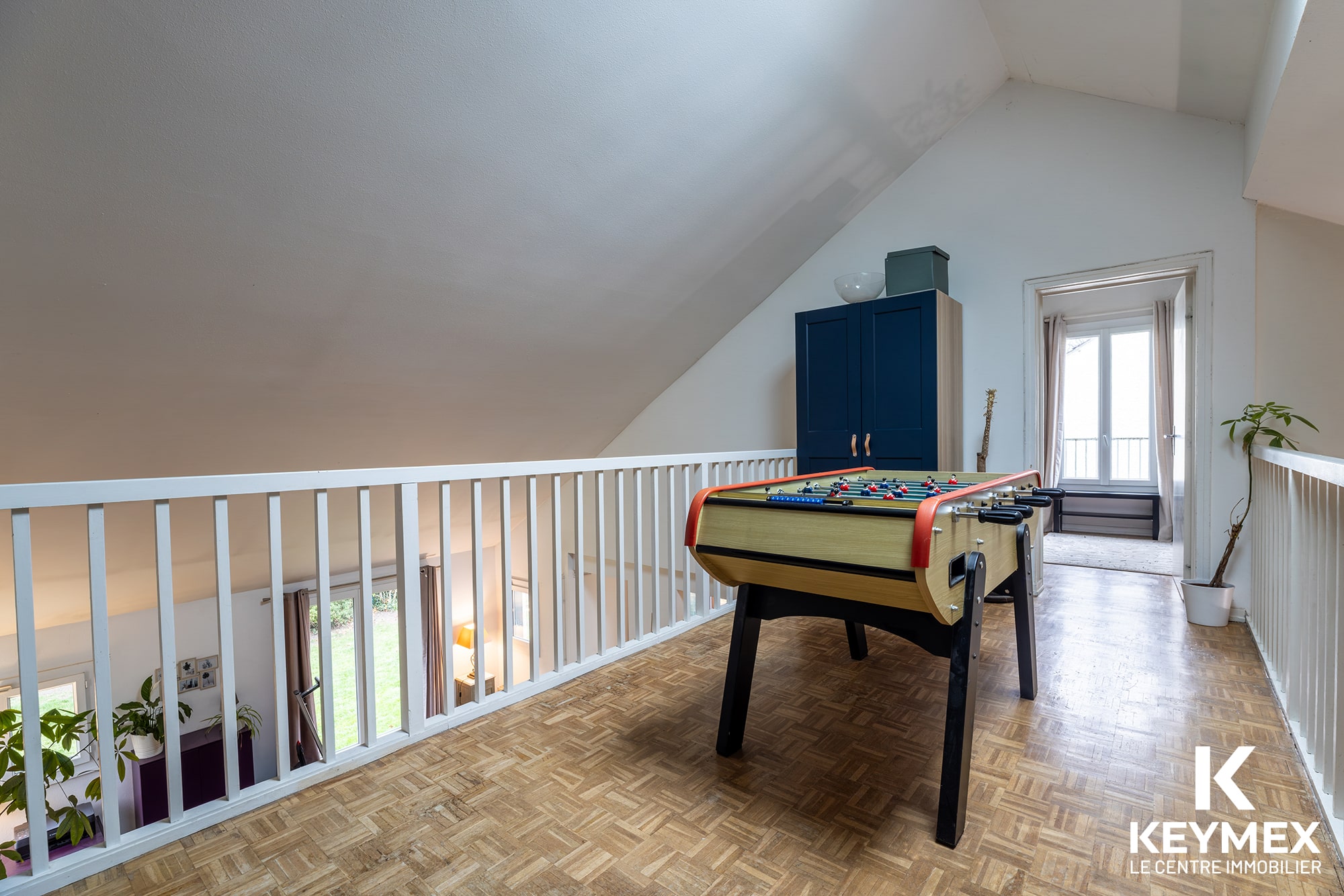 Salle de jeux avec baby-foot sur mezzanine.