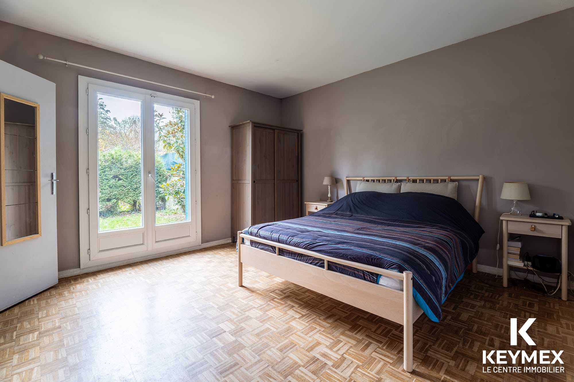 Chambre avec lit double et vue sur jardin.