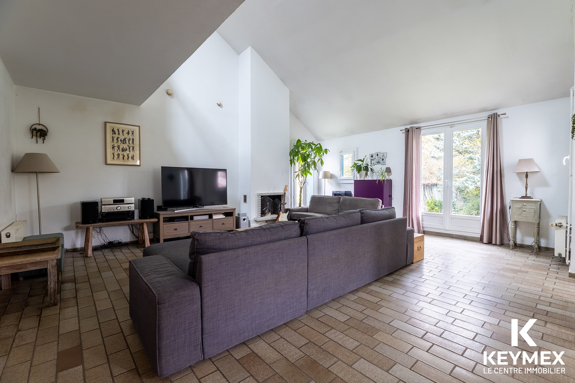 Salon moderne avec canapés et télévision.