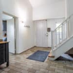 Entrée maison lumineuse avec escalier moderne.