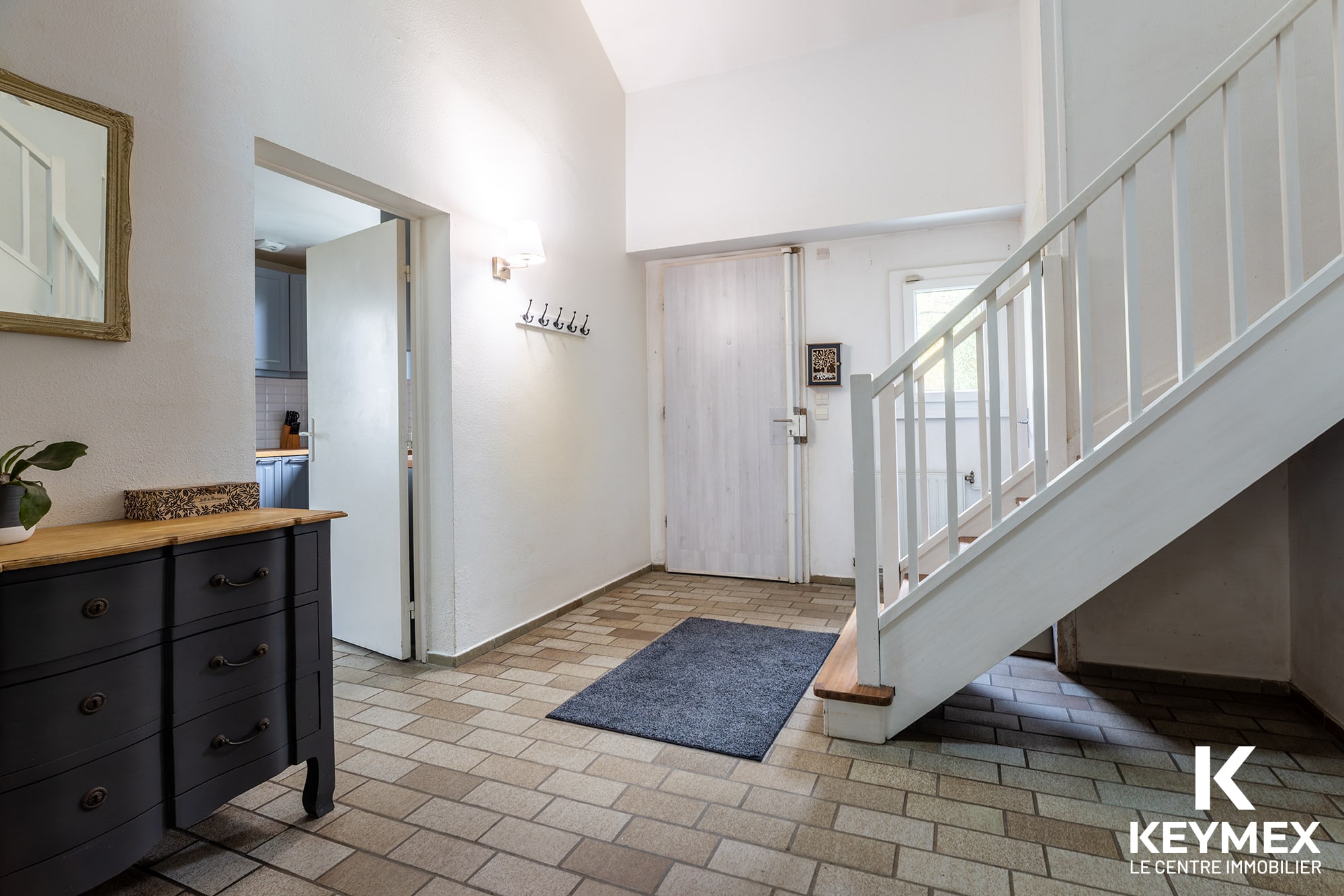 Entrée maison lumineuse avec escalier moderne.