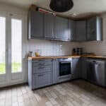 Cuisine moderne avec armoires grises et électroménagers.