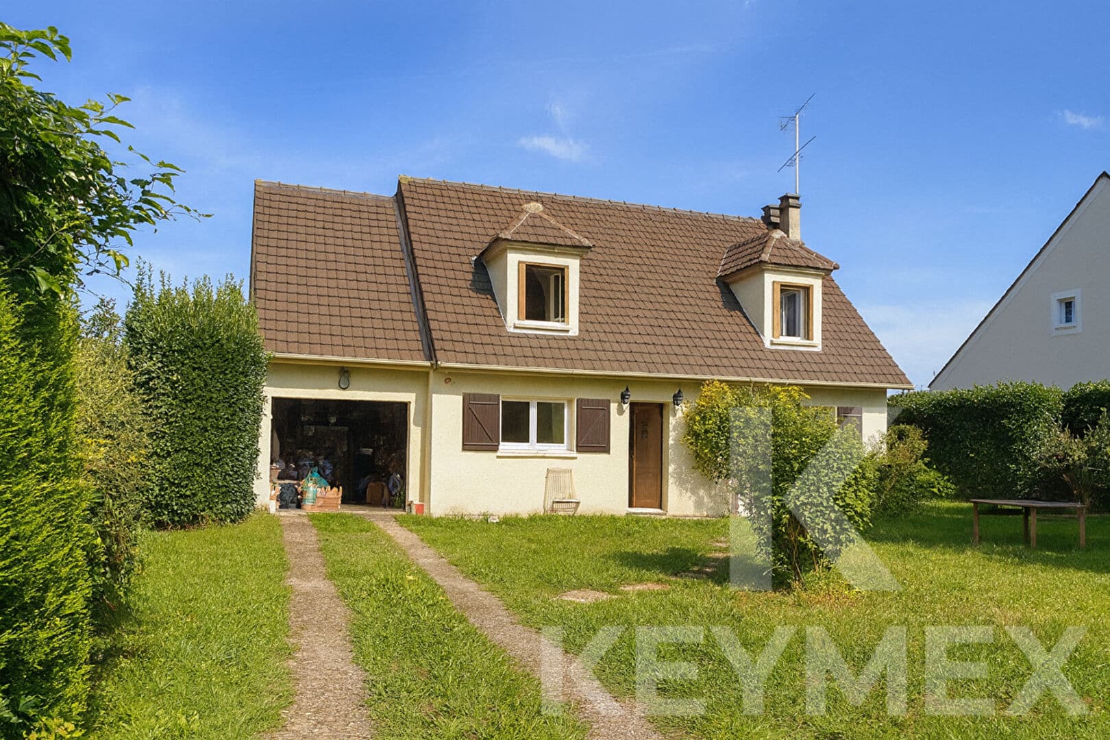 Maison traditionnelle avec jardin, ciel bleu
