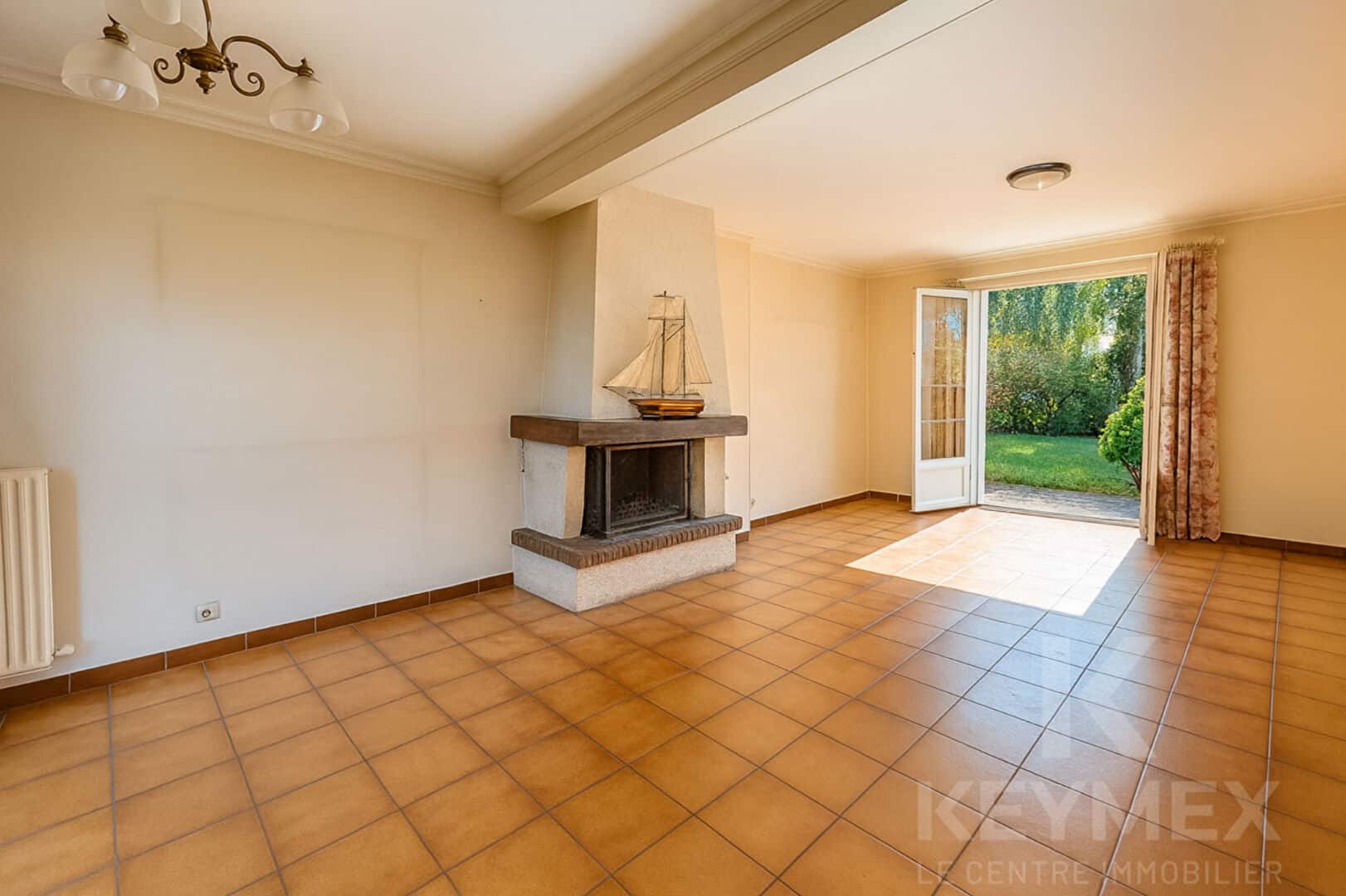 Salon lumineux avec cheminée et vue jardin