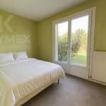 Chambre moderne avec lit double et vue jardin.