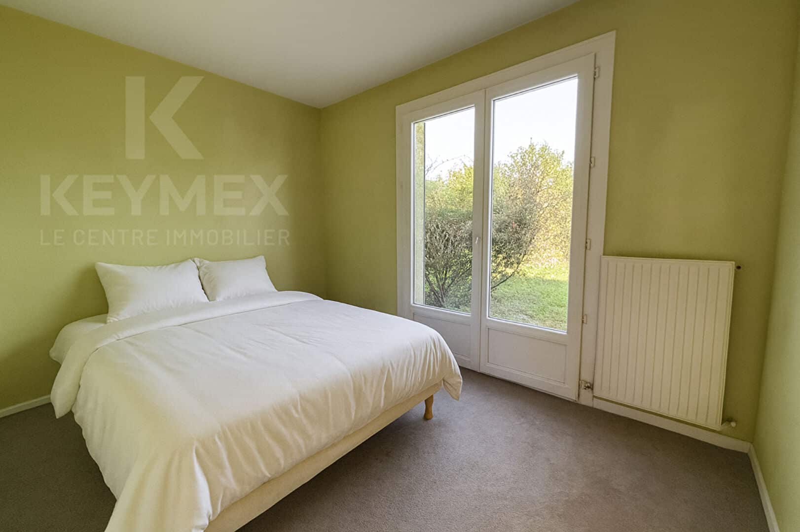 Chambre moderne avec lit double et vue jardin.