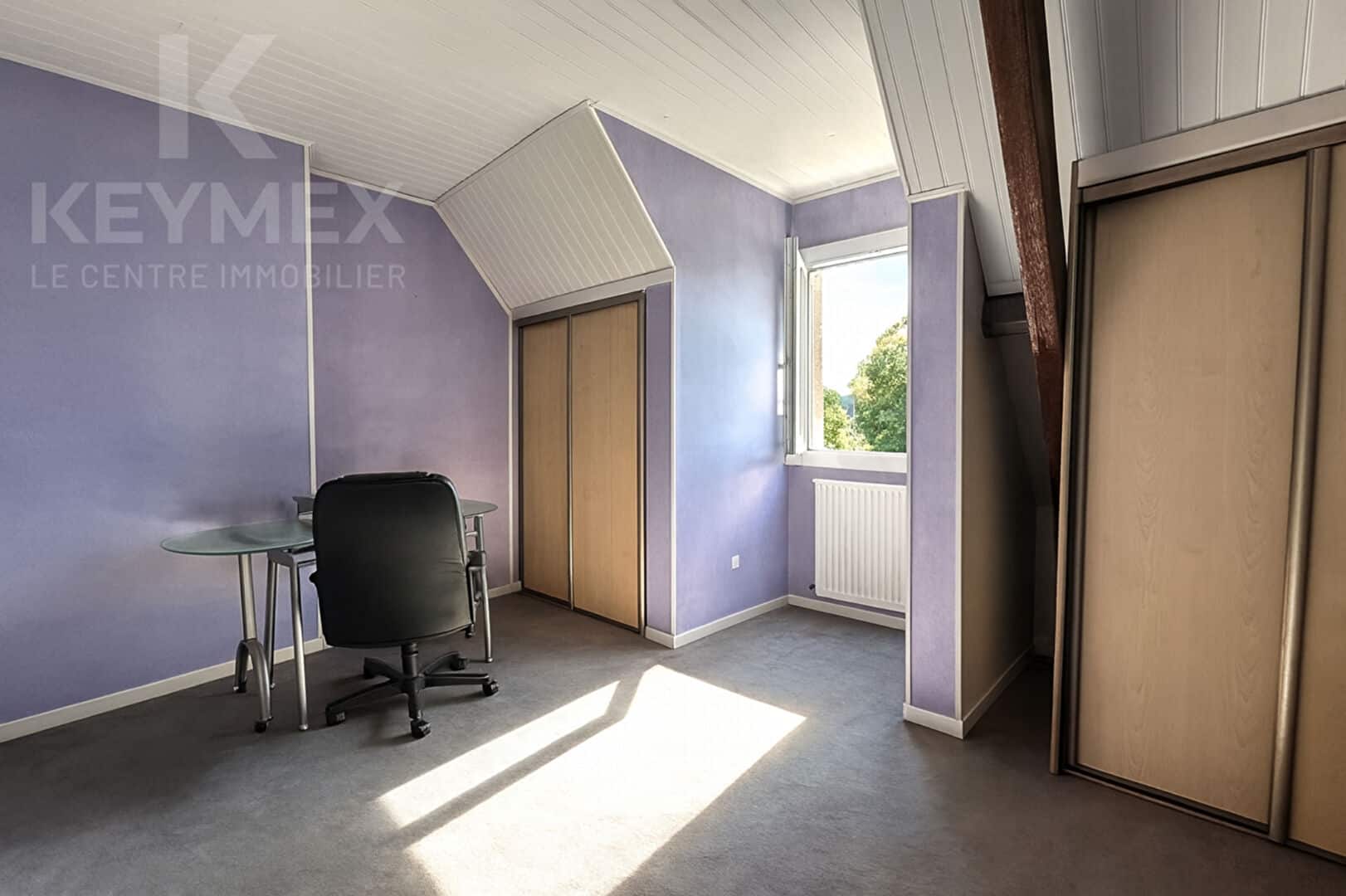 Bureau avec murs violets et fenêtres ouvertes, lumineux.