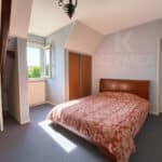 Chambre lumineuse avec lit double et fenêtre ouverte.