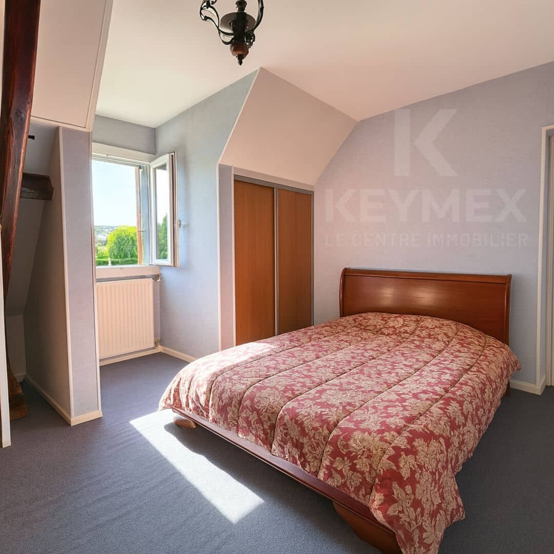 Chambre lumineuse avec lit double et fenêtre ouverte.