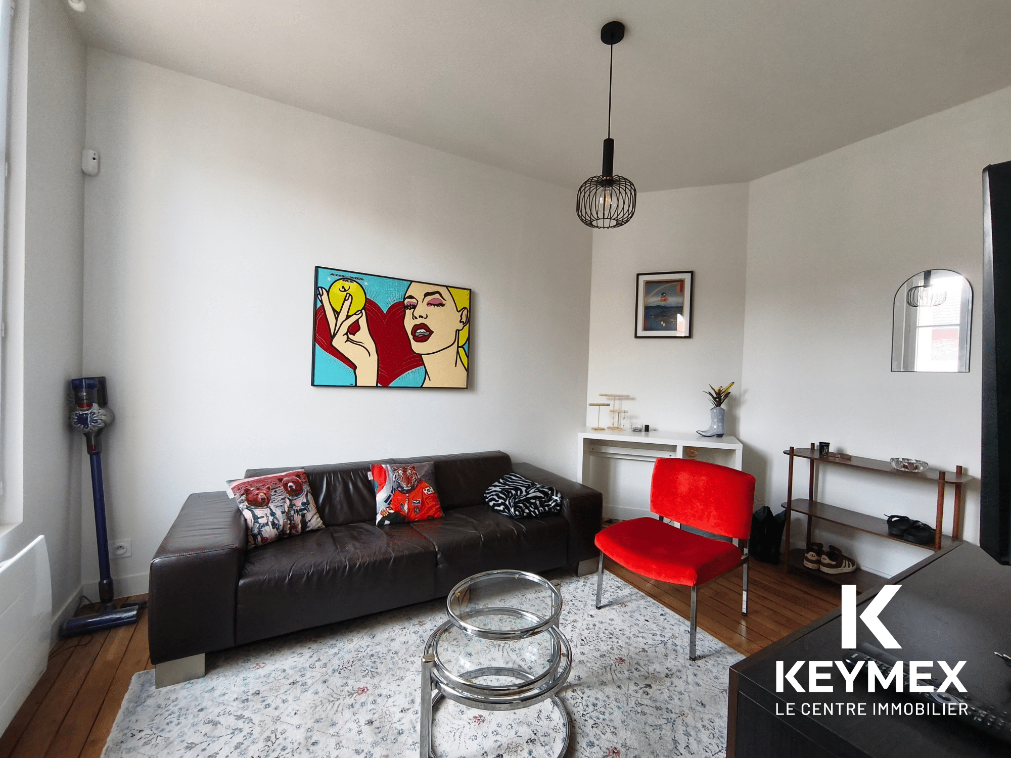 Salon moderne avec canapé et décoration murale colorée.